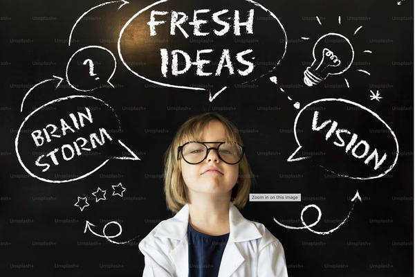 A young girl in a lab coat with fresh ideas on a chalkboard